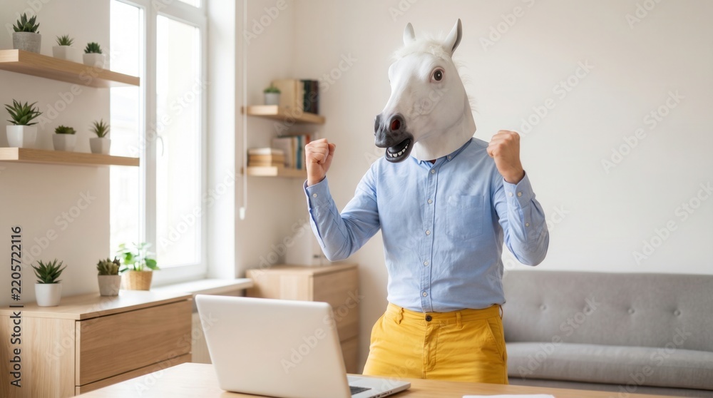 Fototapeta premium Funny man wearing horse head mask celebrating success with raised fists in blue shirt against home office background with shelves and boxes. Concept of humor and unexpected joy
