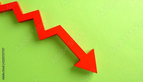 Red arrow pointing down on a vibrant green background, symbolizing financial decline and loss