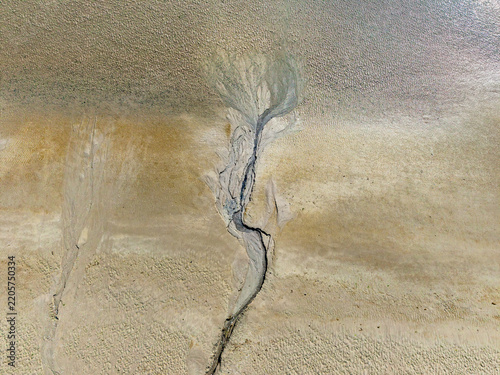 Aerial view of the intricate tidal channels and sand patterns of the Baie de Somme at low tide, showcasing natural textures in Saint-Valery-sur-Somme, Hauts-de-France, France.