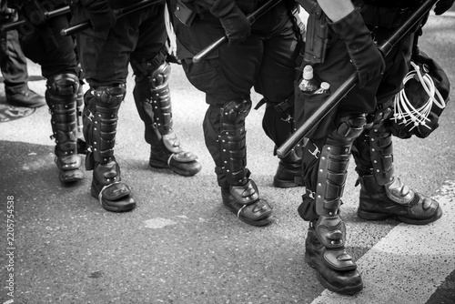 A line of police officers wearing full riot gear