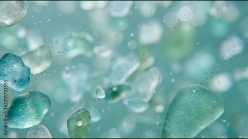 Ocean conservation technology is visualized through translucent sea-glass microfragments suspended abstract material background