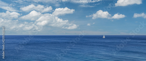 Serene deep blue sunny sea tiny white sailboat wide open bright horizon summer clear sky minimal seascape. Peaceful nature meditation scene. Inspiring tranquil coastal solitude relax wellbeing travel