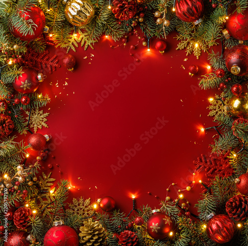 Elegant Christmas frame of fir branches and festive red baubles