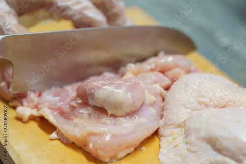 Obraz na płótnie 鶏もも肉を包丁で切る