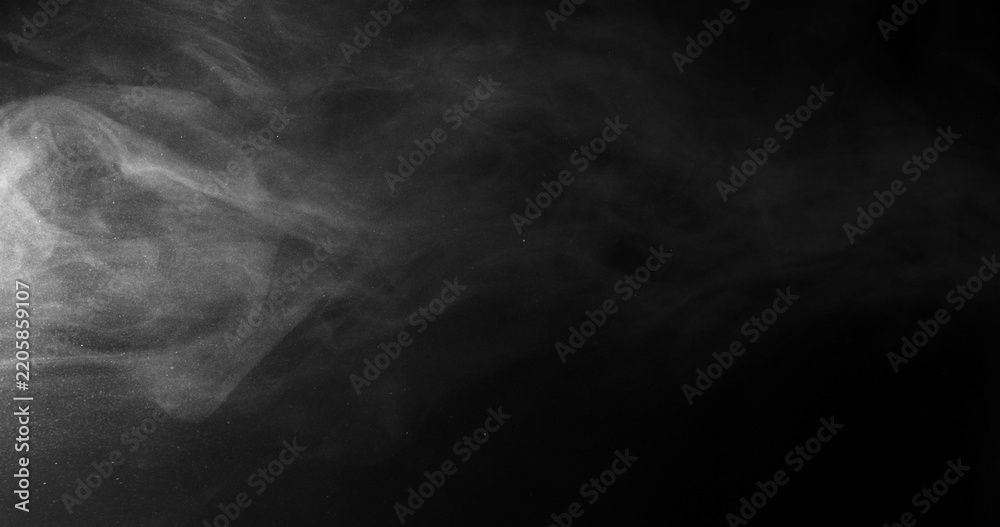 Obraz premium White smoke swirling and dissipating in dark background with wispy tendrils drifting across frame