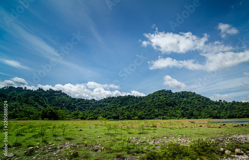 Scenic green grass mountain landscape under beautiful blue sky
