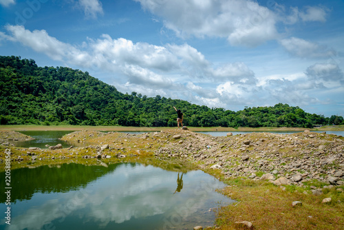 Sai Thong Reservoir surrounded by green mountains under cloudy sky in Nakhon Nayok, Thailand. Beautiful nature landscape.
