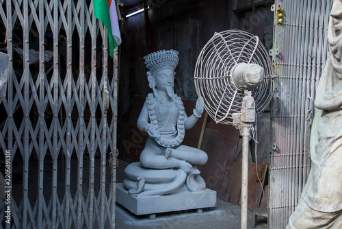 An artisan's workshop in Kolkata's historic Kumartuli district during the idol-making season. An unfinished clay sculpture of Goddess Kali sits in the traditional lotus position (Padma Asan mudra)