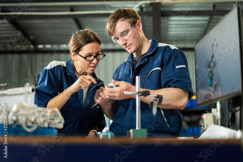 Engineers Examining Mechanical Component in Manufacturing Factory