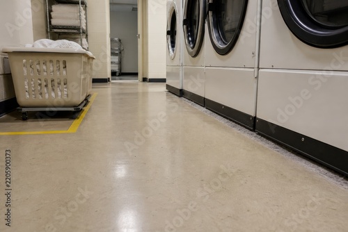 Commercial laundry dryer lint fire prevention housekeeping risk beside a stopped machine