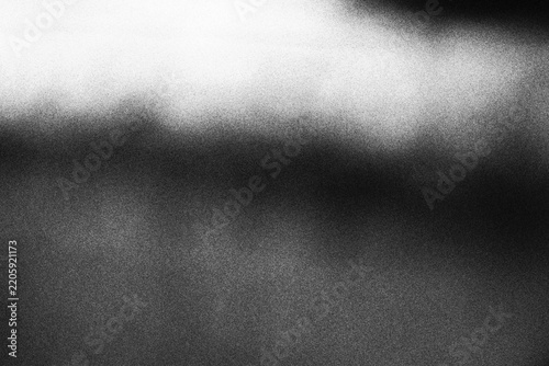 Abstract black and white grainy texture background with soft light gradient