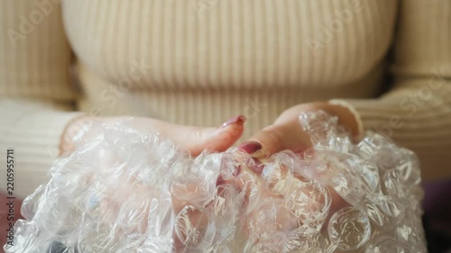 Woman's hands popping bubble wrap for ASMR sound and relaxation stress relief.