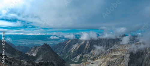 Panoramic view of mountain peaks hidden in clouds. The High Tatras seen from Rysy. Tatra Mountains.