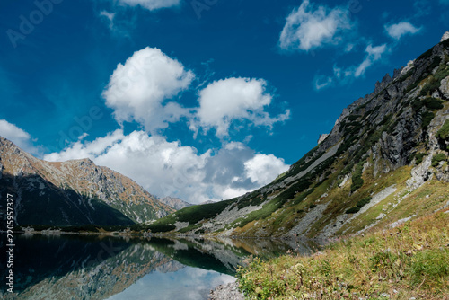 Mountain landscape with a pond and clouds. Czarny Staw pod Rysami in the High Tatras.