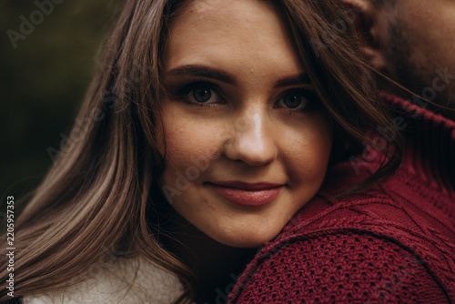 Young woman leaning on shoulder in outdoor setting.