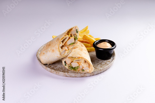 Chicken wrap halves with french fries and dipping sauce food