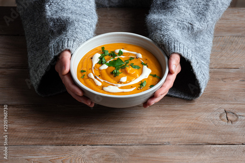 Bowl of red lentil soup in woman hands