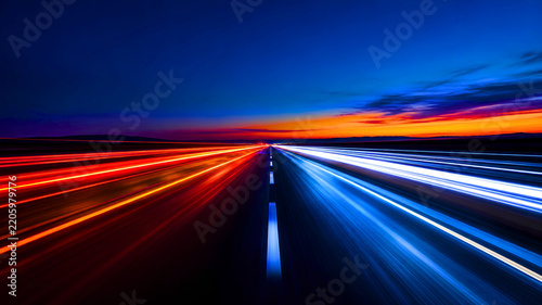 Night Highway Traffic With Red and Blue Long Exposure Light Trails Leading Toward Sunset Horizon With Dynamic Speed and Motion