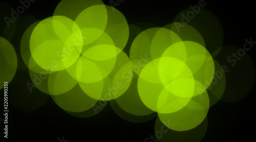 Abstract green out of focus bokeh light circles over a solid black background