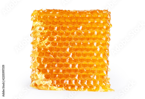 Piece of wax honeycomb filled with honey, isolated on white background.