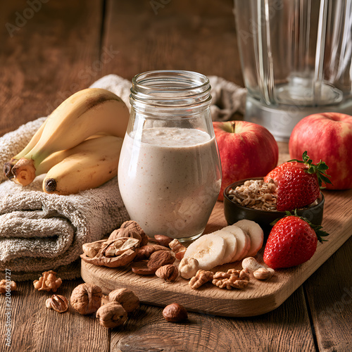 Nutritious Plant Based Milk with Fresh Fruit and Mixed Nuts on Wooden Table