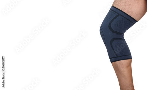 Man's leg wearing black compression knee brace for muscle rehabilitation and joint support on white.
