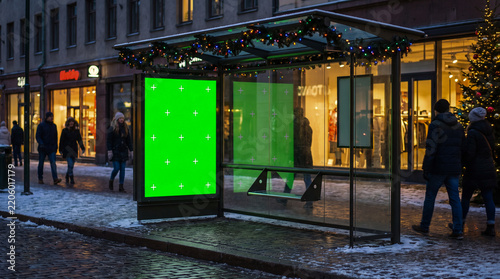 Marquesina de autobús hiperrealista con mupi en pantalla verde y marcas de seguimiento, ubicada en una calle urbana iluminada con luces de Navidad y ambiente festivo invernal.