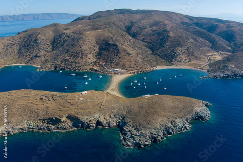 Kythnos, Greece - 21 September 2026: Aerial view of Kolona Beach, a double-sided sandy tombolo connecting the island to a rocky islet with anchored sailing boats.
