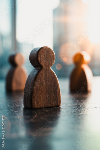 Wooden human figures standing on a dark surface