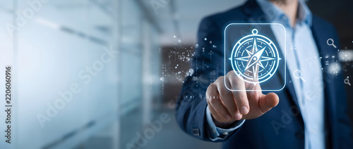 Businessman pointing to a glowing digital compass icon on a virtual interface, symbolizing strategic direction, navigation towards business goals, leadership guidance, and vision for success.