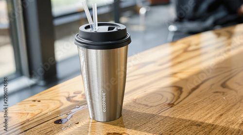 Stainless Steel Travel Mug with Straws on Wooden Table