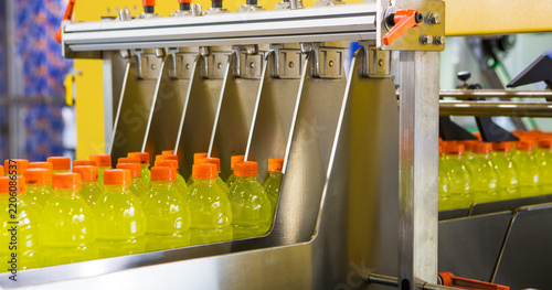 Yellow sports drink bottles moving along a production line
