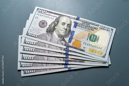 Hundred dollar bills spreading on dark surface