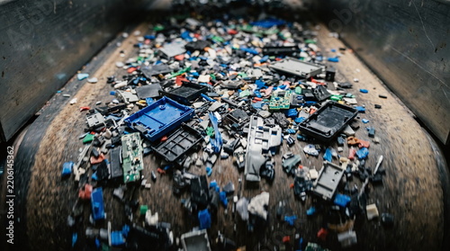 Crushed electronics and plastic pieces moving on a conveyor line during e-waste processing