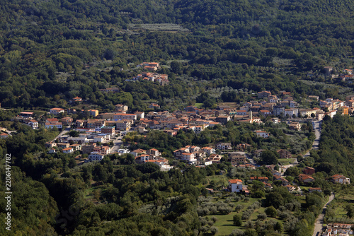 Panoramic aerial view of the rural village of San Clemente surrounded by green forests from Mount Camino, Caserta, Italy
