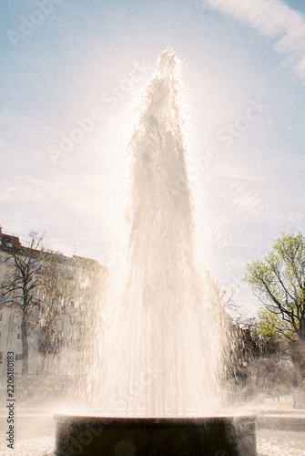 Sunlit water fountain erupting in a city park