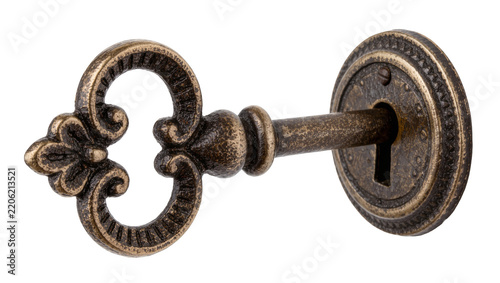 Antique ornate bronze key inserted into a decorative keyhole, isolated on transparent background