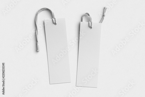Two blank white bookmarks with cotton string on textured paper background, flat lay mockup