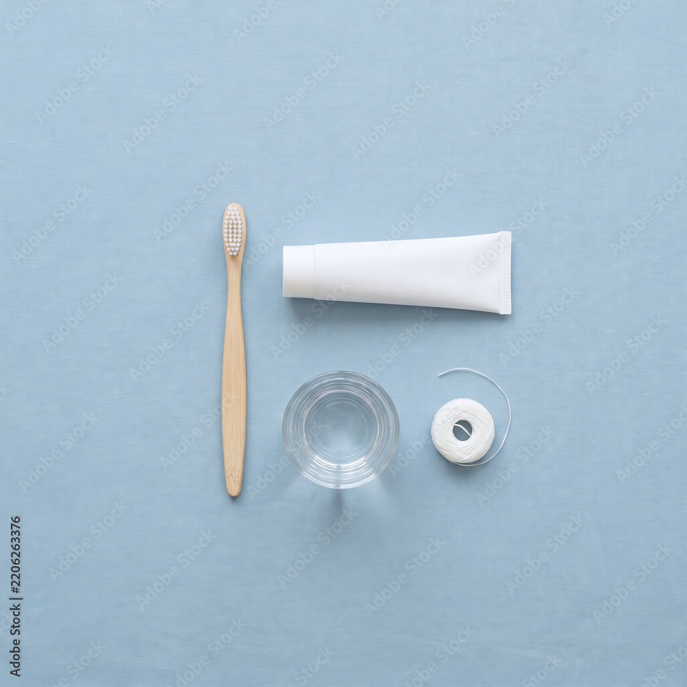 Obraz premium Overhead flat lay of oral hygiene essentials on soft pastel blue background
