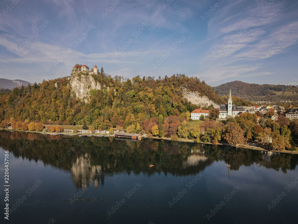 Fototapeta premium Bled Castle and Assumption of Mary Church Reflecting on Lake Bled in Autumn