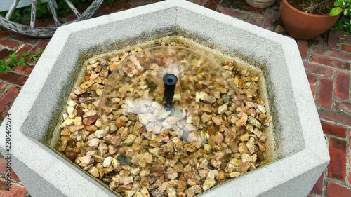 庭の六角形の水盤でドーム状に広がる噴水の水流