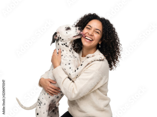 Woman hugging spotted dalmatian puppy dog laughing isolated studio