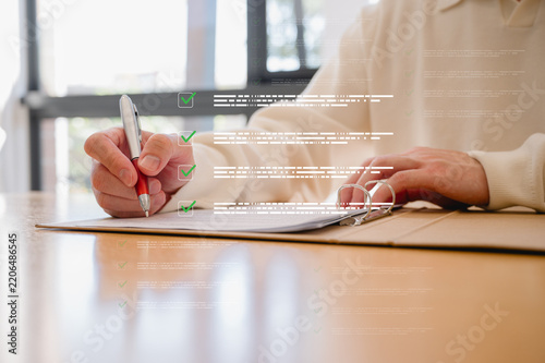 Businessman using pen, completing checklist on document in data system Report HR technology Concept, A checklist for policy implementation featuring a standard and official approved documents