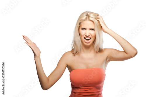 Obraz na plátně Woman with light hair showing frustration while raising her arms indoors with a