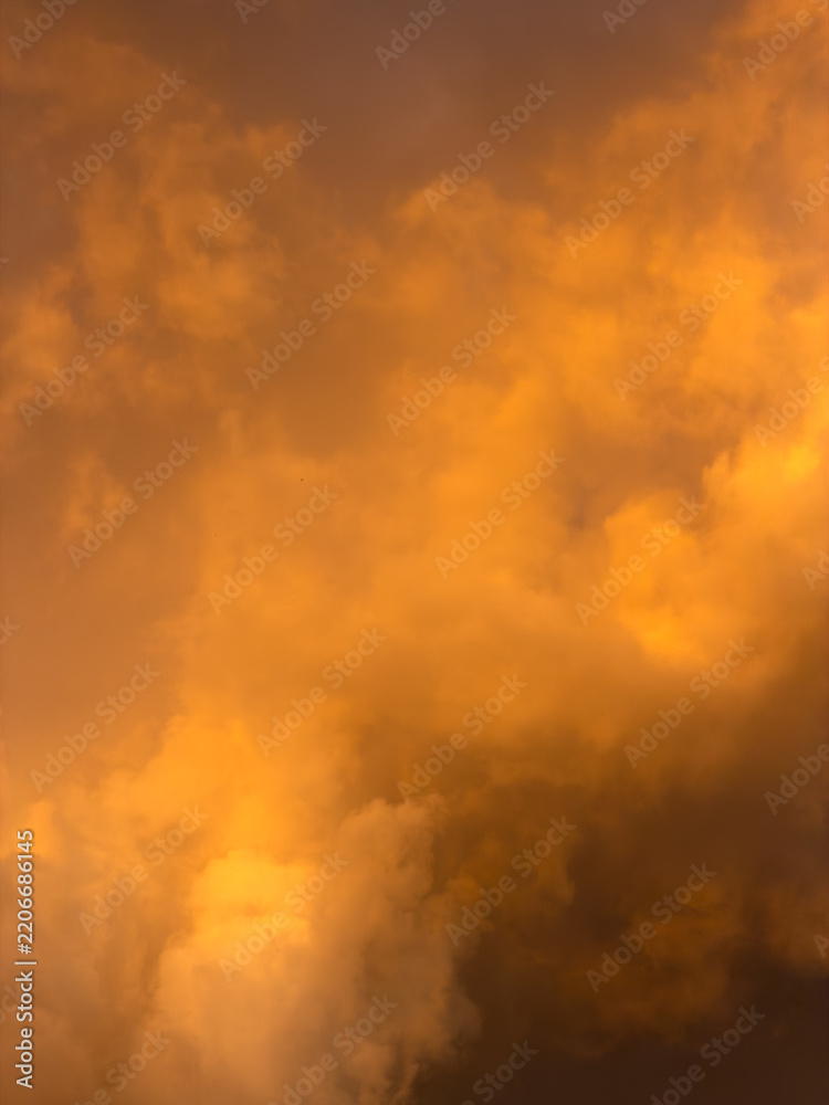 Fototapeta premium Warm, golden clouds glow against dusky sky