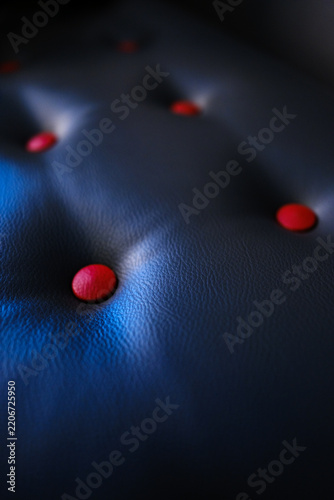 Obraz na plátně Quilted leather upholstery in macro with red buttons under cool blue light