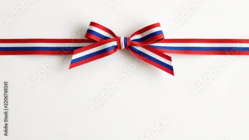 Red white and blue striped ribbon bow on white background