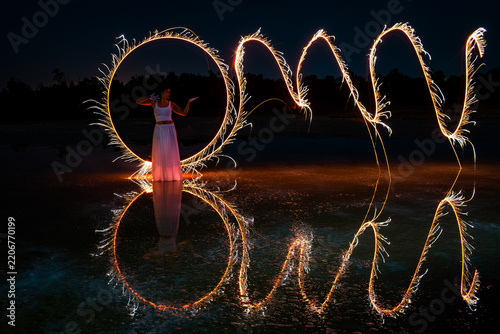 Woman posing for light painting photos Reflection in the water