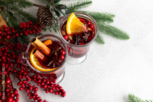 Warm mulled wine drinks with spices and fruits on a table with festive decorations