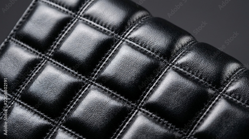 Fototapeta premium Premium Close Up of Black Quilted Synthetic Leather Fabric with Square Stitching Detail for Luxury Fashion and Interior Design